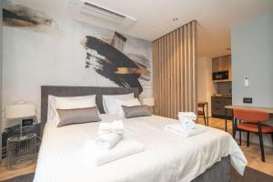 a bedroom with a large white bed with two towels at Apartments Villa Royale in Cavtat