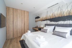 a bedroom with a large white bed and wooden cabinets at Apartments Villa Royale in Cavtat