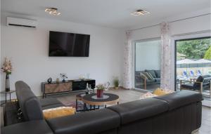 sala de estar con sofá negro y TV en 3 Bedroom Awesome Home In Labin en Labin
