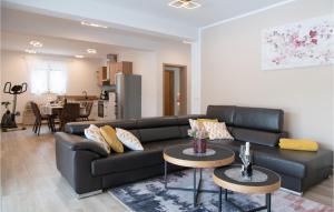 una sala de estar con un sofá de cuero negro y mesas. en 3 Bedroom Awesome Home In Labin en Labin