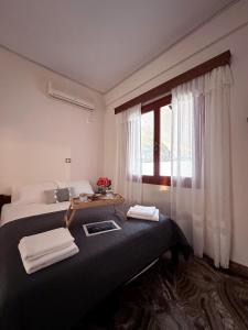 a hotel room with two beds and a window at Salamis Luxury Escape in Salamís