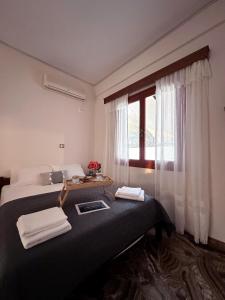 a hotel room with two beds and a window at Salamis Luxury Escape in Salamina