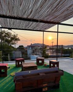 a patio with benches and a view of the sunset at Salamis Luxury Escape in Salamina