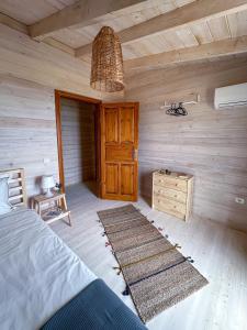 a bedroom with a bed and a wooden wall at Assos Sizin Ev in Ayvacık