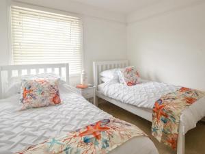a bedroom with two twin beds and a window at River Lym Cottage in Lyme Regis