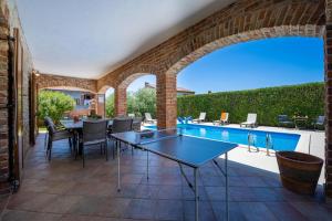an outdoor patio with a table and chairs and a swimming pool at Villa Amani in Butkovići