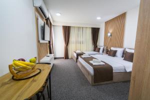 a hotel room with a bed and a table at Rooftop apartments & rooms Budva in Budva