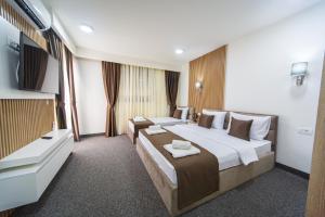 um quarto de hotel com uma cama grande e uma televisão de ecrã plano em Rooftop Apartments & Rooms em Budva