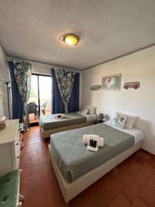 クアルテイラにある2 Bedroom Apartment in Quarteira with Balcony, Pool and Wi-Fi by Centralgarveのベッド2台と窓が備わるホテルルームです。
