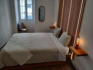 a bedroom with a large white bed and a window at Santi e Benny Apartment in Ponta Delgada