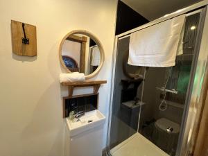 a bathroom with a shower and a sink and a mirror at Explorers Retreat Matlock Bath in Matlock