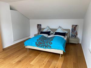 Schlafzimmer mit einem Bett mit blauer Decke in der Unterkunft Alpenland Apartments in Aschau im Chiemgau