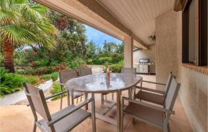 een eetkamer met een tafel en stoelen op een patio bij Lovely Home In Vias With Outdoor Swimming Pool in Vias