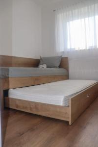 2 camas individuais num quarto com pisos em madeira em Apartman Matea em Topići
