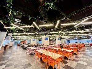 a dining hall with tables and chairs and lights at Kuching Kozi Square Apartment (II) in Kuching