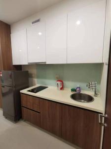 cocina con fregadero y nevera en Kuching Kozi Square Apartment (II) en Kuching