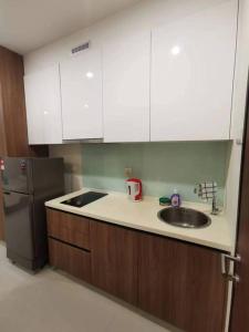 a kitchen with a sink and a refrigerator at Kuching Kozi Square Apartment (II) in Kuching +16 photos