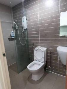 uma casa de banho com um chuveiro, um WC e um lavatório. em Kuching Kozi Square Apartment (II) em Kuching