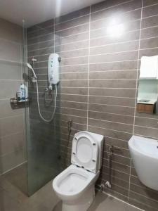 uma casa de banho com um chuveiro, um WC e um lavatório. em Kuching Kozi Square Apartment (II) em Kuching