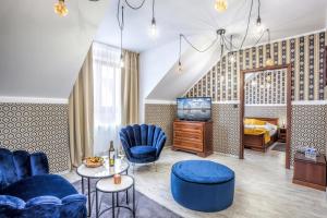una habitación de hotel con sillas azules y un dormitorio en Hotel Beta en Bzenec