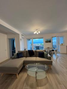 Una sala de estar con un sofá y una mesa de cristal. en Azzurro Apartment, en Sibiu