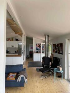 sala de estar con sofá azul y cocina en Really Nice And Big Summerhouse Close To Roskilde Fjord, en Ølsted
