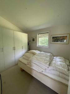 1 cama grande en un dormitorio con ventana en Really Nice And Big Summerhouse Close To Roskilde Fjord, en Ølsted