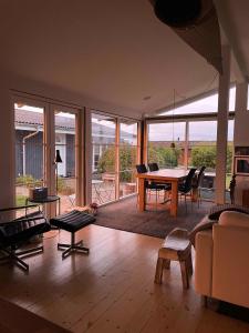 sala de estar con mesa, sillas y sofá en Really Nice And Big Summerhouse Close To Roskilde Fjord, en Ølsted