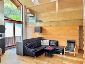 a living room with a leather couch and a table at StarkApart - XL-Wohnung-geräumig-stilvoll in Ried im Oberinntal