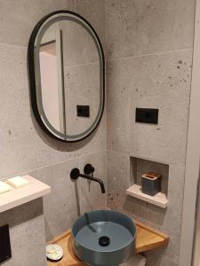 ein Badezimmer mit einem blauen Waschbecken und einem Spiegel in der Unterkunft Sun city lifestyle in Poreč