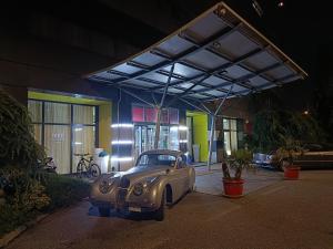 an old car parked in front of a building at Green Hotel Ninfa in Avigliana