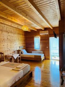 a bedroom with two beds in a wooden room at Bujtina Dini in Rubik
