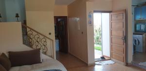 a bedroom with a bed and a staircase with a door at Welcome Duplex in El Jadida