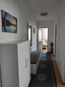 ein Wohnzimmer mit weißen Schränken und einem Sofa in der Unterkunft Ajsha Guesthouse in Jajce