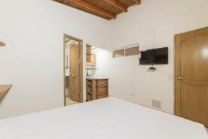 a kitchen with white walls and a wooden door at Discover urban life in the heart of Medellin 202 in Medellín
