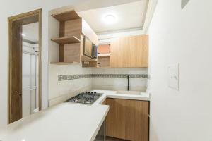 a small kitchen with a stove and a sink at Discover urban life in the heart of Medellin 202 in Medellín