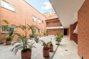 a courtyard with potted plants in front of a brick building at Discover urban life in the heart of Medellin 202 in Medellín
