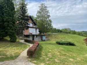 una casa en una colina de hierba con un camino que conduce a ella en Vila Krcedin en Krčedin
