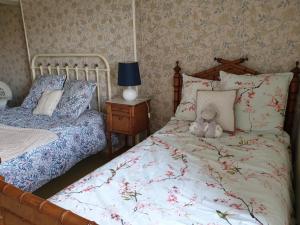 a teddy bear sitting on a bed in a bedroom at La Barboulotte in Saint-Léger-Vauban