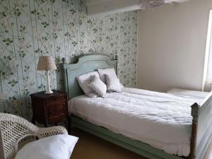 a bedroom with a bed with a lamp and a chair at La Barboulotte in Saint-Léger-Vauban +2 photos