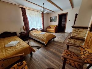 a living room with two beds and a fireplace at GOŚCINIEC GŁODOWO in Ruciane-Nida