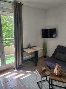 a living room with a couch and a table at Appartement Proche DisneyLand Paris in Montévrain