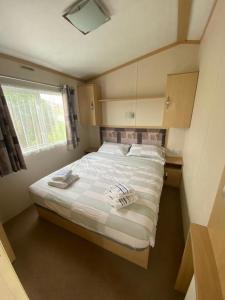 um quarto com uma cama grande e toalhas em Cascade Lodge & Hot Tub em Donegal