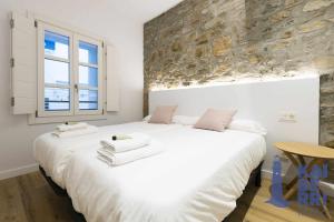sypialnia z dużym białym łóżkiem i oknem w obiekcie Ubilla by Kaiberri Inmo w mieście Hondarribia