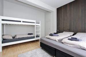 a bedroom with two beds and a bunk bed at LL Properties - H99 Main Street Stay in Akureyri