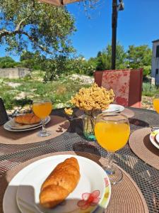 uma mesa com um prato de pão e copos de sumo de laranja em Marija Holiday Home em Sućuraj