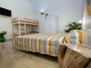 a bedroom with a bed with a striped blanket at Terra De Mare in Palmariggi