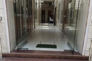 an empty hallway in a building with glass doors at IFM Guest House in Amritsar