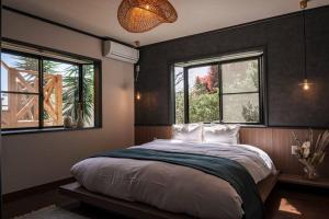 Ajiro的住宿－Villa Arancia，一间卧室设有一张大床和两个窗户。