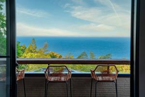 Ajiro的住宿－Villa Arancia，阳台上的两把椅子,俯瞰着大海